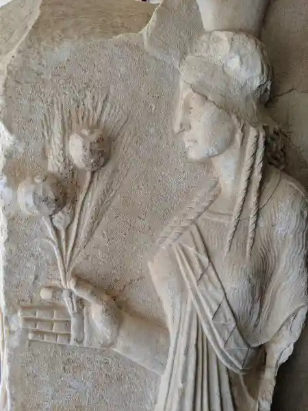 Close up of Demeter, marble relief base depicting Demeter, Zeus Chthonios and Persephone in archaic revival style from Roman period. 